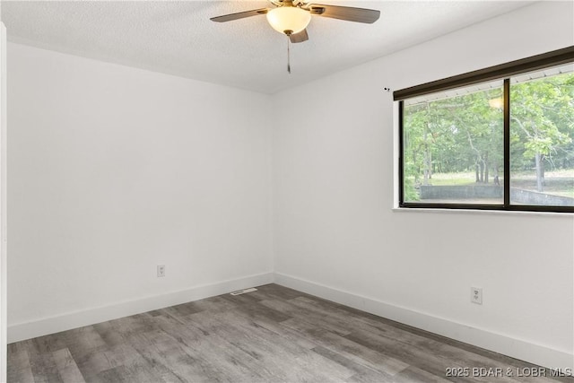 1318 Evergreen Ln Unit 4, Osage Beach, MO 65065 - unfurnished room with wood finished floors, a ceiling fan, baseboards, and a textured ceiling