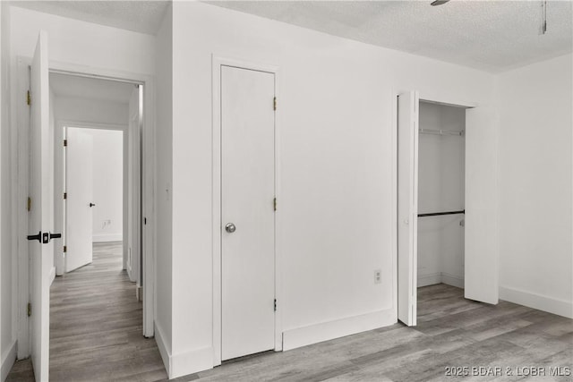 1318 Evergreen Ln Unit 4, Osage Beach, MO 65065 - unfurnished bedroom with wood finished floors, a textured ceiling, and baseboards