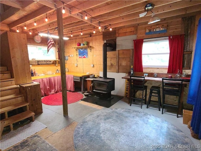 31025 Broken Circle Rd, Stover, MO 65078 - below grade area with a wood stove, wooden walls, rail lighting, and stairway