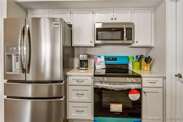 701 Cedar Rd Unit 1A, Lake Ozark, MO 65049 - kitchen with appliances with stainless steel finishes, light countertops, and white cabinets
