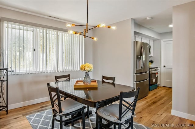 701 Cedar Rd Unit 1A, Lake Ozark, MO 65049 - dining space featuring a chandelier, baseboards, and light wood finished floors