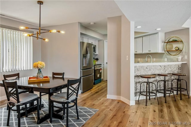 701 Cedar Rd Unit 1A, Lake Ozark, MO 65049 - dining room featuring baseboards, light wood-style floors, a chandelier, and recessed lighting