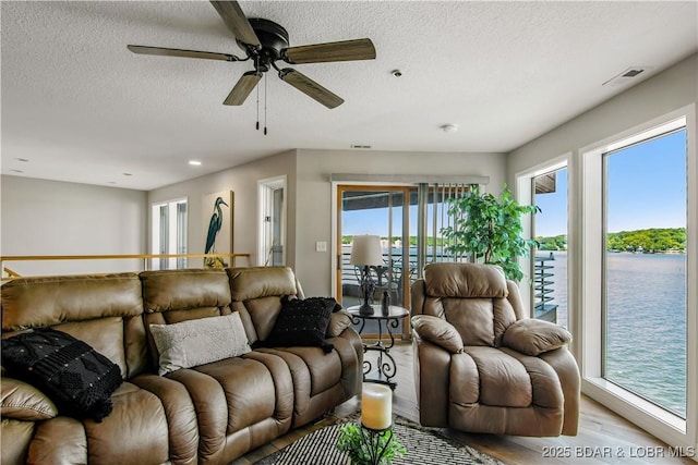 701 Cedar Rd Unit 1A, Lake Ozark, MO 65049 - living room featuring wood finished floors, ceiling fan, a textured ceiling, a water view, and recessed lighting
