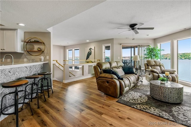 701 Cedar Rd Unit 1A, Lake Ozark, MO 65049 - living room featuring wood-type flooring, a textured ceiling, healthy amount of natural light, ceiling fan, and baseboards