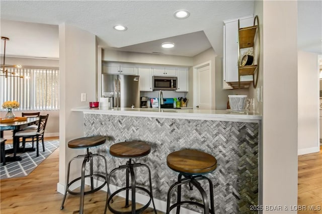 701 Cedar Rd Unit 1A, Lake Ozark, MO 65049 - kitchen featuring stainless steel appliances, light wood finished floors, baseboards, a breakfast bar area, and recessed lighting