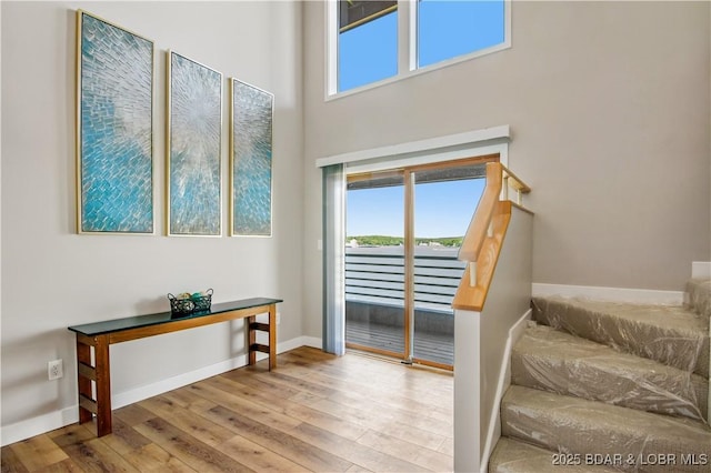 701 Cedar Rd Unit 1A, Lake Ozark, MO 65049 - stairs with hardwood / wood-style floors, healthy amount of natural light, baseboards, and a towering ceiling