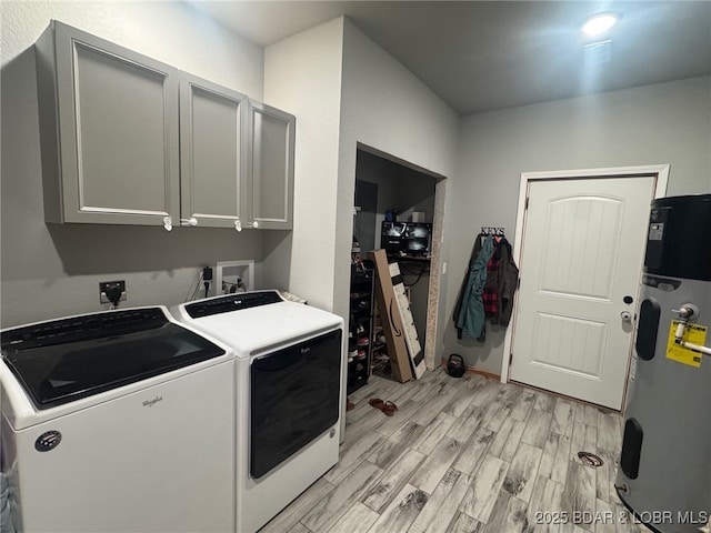 1760 Deans Creek Rd, Richland, MO 65556 - laundry room featuring heat pump water heater, washer and clothes dryer, cabinet space, and light wood-style floors