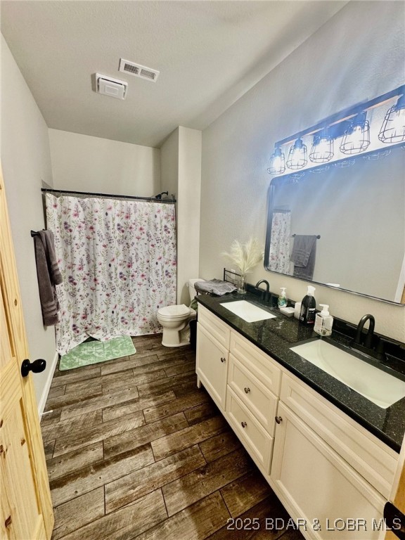 1760 Deans Creek Rd, Richland, MO 65556 - full bath featuring wood-type flooring, double vanity, toilet, and curtained shower
