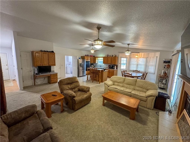 18400 Alum Springs Rd, Versailles, MO 65084 - living room featuring ceiling fan, light carpet, a textured ceiling, vaulted ceiling, and washer / dryer