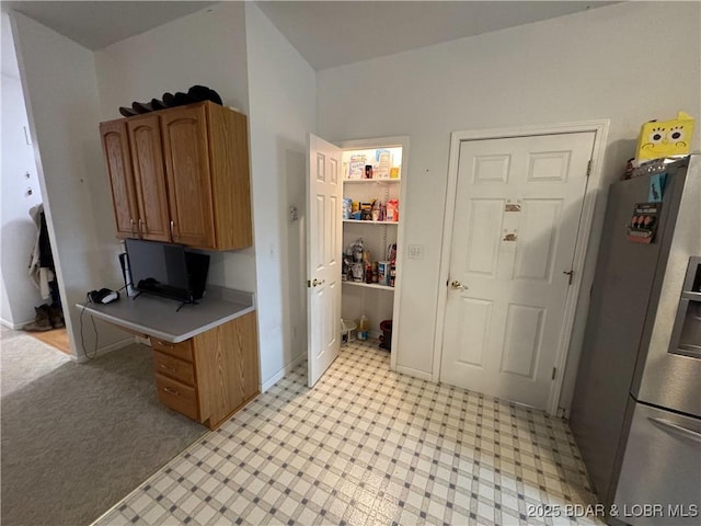 18400 Alum Springs Rd, Versailles, MO 65084 - kitchen featuring stainless steel fridge with ice dispenser, light countertops, brown cabinetry, a desk, and light flooring