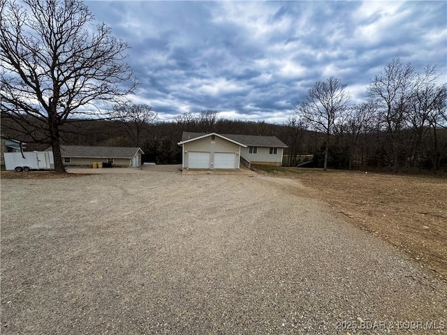 18400 Alum Springs Rd, Versailles, MO 65084 - view of front of home with an outdoor structure, dirt driveway, and an attached garage