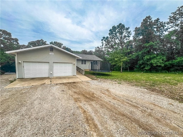 18400 Alum Springs Rd, Versailles, MO 65084 - view of front of property featuring a trampoline, driveway, an outbuilding, and a front lawn