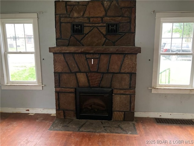 203 S Hunter St, Versailles, MO 65084 - detailed view of wood finished floors, baseboards, and a stone fireplace