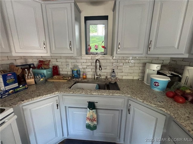 406 Staley Hollow Dr, Sunrise Beach, MO 65079 - kitchen with a sink, backsplash, white cabinets, and light stone counters