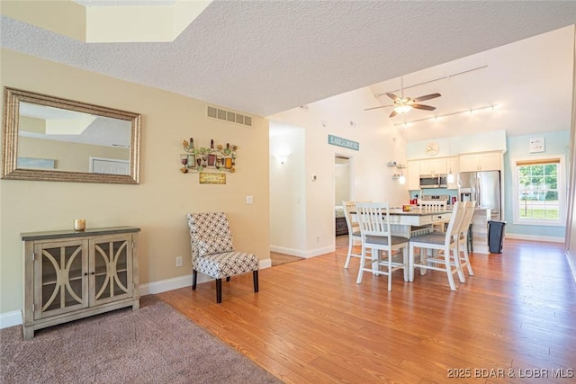 4066 Horseshoe Bend Pkwy Unit 3A, Lake Ozark, MO 65049 - dining room featuring light wood finished floors, a ceiling fan, baseboards, vaulted ceiling, and a textured ceiling