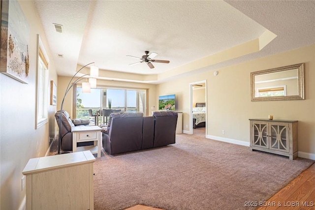 4066 Horseshoe Bend Pkwy Unit 3A, Lake Ozark, MO 65049 - carpeted living area featuring a ceiling fan, a textured ceiling, baseboards, and a tray ceiling