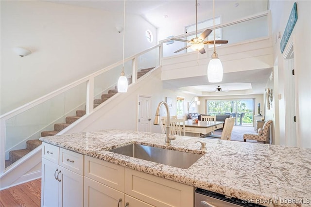 4066 Horseshoe Bend Pkwy Unit 3A, Lake Ozark, MO 65049 - kitchen with a sink, a ceiling fan, hanging light fixtures, light stone countertops, and a towering ceiling