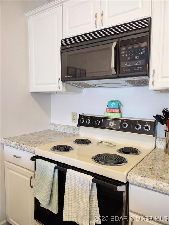 2500 Bay Point Ln Unit 342, Osage Beach, MO 65020 - kitchen with white electric stove, black microwave, and white cabinetry