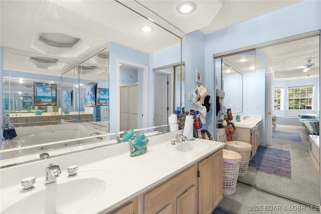 289 Charleston Dr Unit 2B, Lake Ozark, MO 65049 - bathroom with double vanity, a jetted tub, a ceiling fan, a textured ceiling, and a stall shower