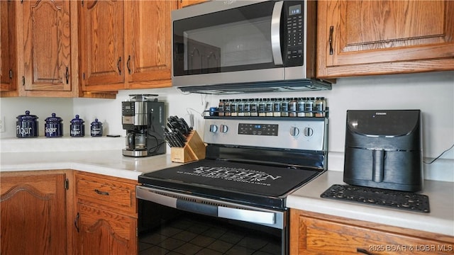 111 Rock Dove Ln Unit 3A, Camdenton, MO 65020 - kitchen with stainless steel appliances, light countertops, and brown cabinetry