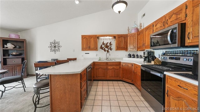 111 Rock Dove Ln Unit 3A, Camdenton, MO 65020 - kitchen with stainless steel appliances, a sink, a peninsula, a kitchen breakfast bar, and light countertops