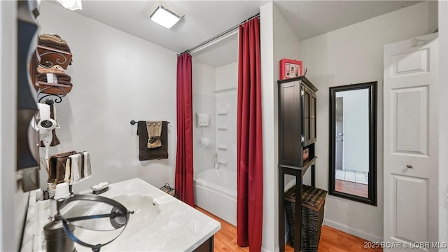 111 Rock Dove Ln Unit 3A, Camdenton, MO 65020 - bathroom with vanity, wood finished floors, shower / bath combo with shower curtain, and baseboards