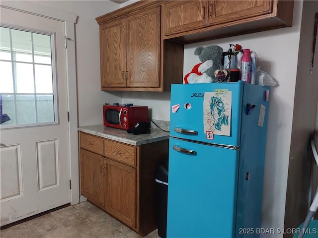 203 3rd St, Stover, MO 65078 - kitchen with freestanding refrigerator, brown cabinets, and light countertops