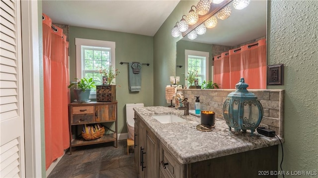 660 Upper Prairie Hollow Rd, Macks Creek, MO 65786 - bathroom with vanity, stone finish flooring, baseboards, a textured wall, and a shower with shower curtain
