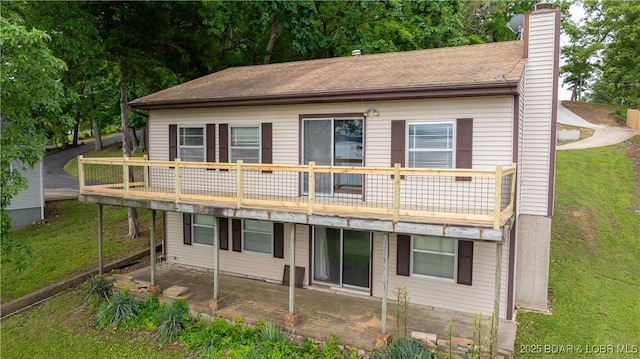 864 Four Waters Dr, Sunrise Beach, MO 65079 - back of house featuring a chimney, a yard, a deck, and a patio