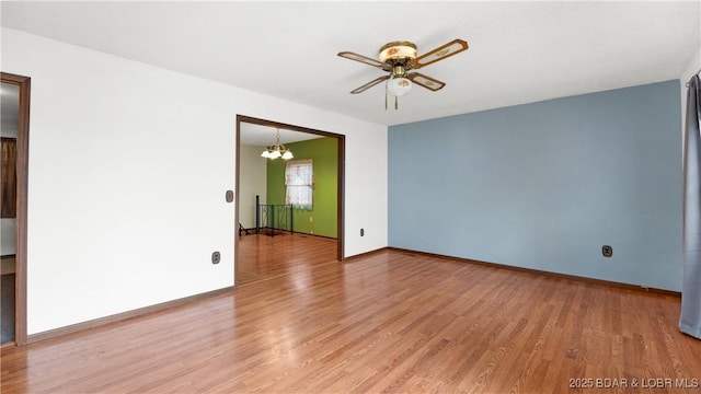 864 Four Waters Dr, Sunrise Beach, MO 65079 - spare room featuring a chandelier, light wood-type flooring, a ceiling fan, and baseboards