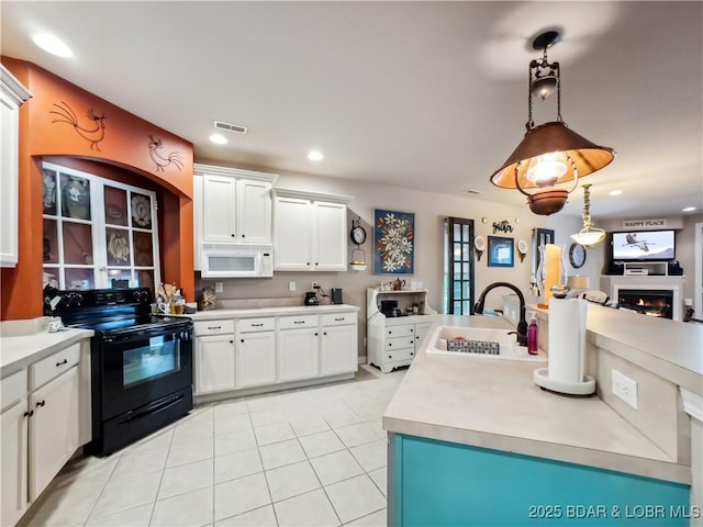 134 Heavenly Days Cir Unit 3A, Camdenton, MO 65020 - kitchen featuring black range with electric stovetop, white microwave, a sink, light tile patterned floors, and white cabinets