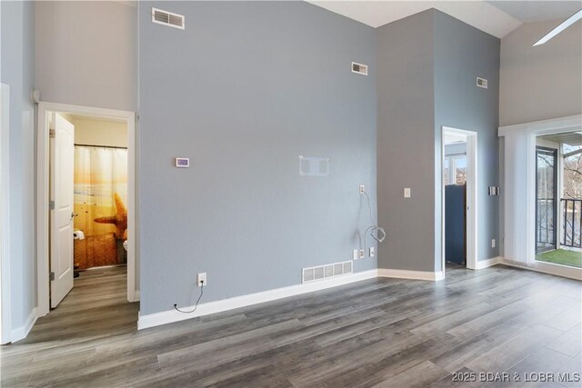 98 Jonathan Dr Unit 4C, Lake Ozark, MO 65049 - unfurnished living room featuring a high ceiling, wood finished floors, and baseboards