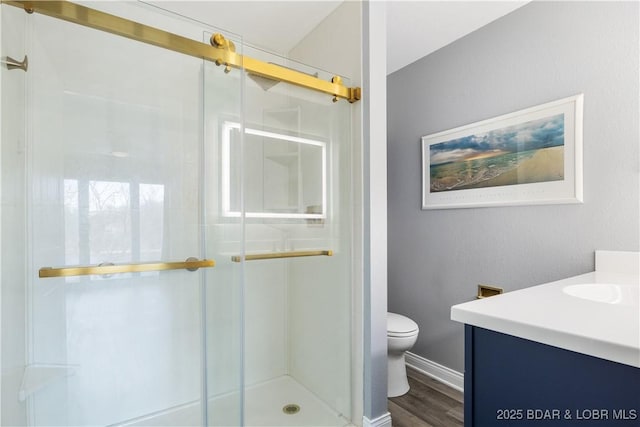 98 Jonathan Dr Unit 4C, Lake Ozark, MO 65049 - full bathroom featuring vanity, a stall shower, toilet, wood finished floors, and baseboards