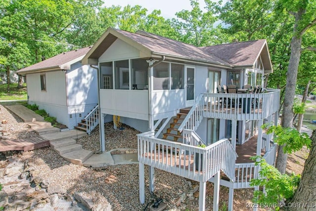42 Rhine River Rd, Sunrise Beach, MO 65079 - view of front facade featuring stairway, a sunroom, roof with shingles, and a wooden deck