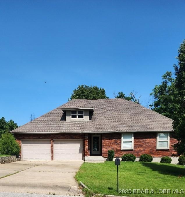 105 Birdie Dr, Gravois Mills, MO 65037 - view of front of house with concrete driveway, a garage, a front lawn, and brick siding
