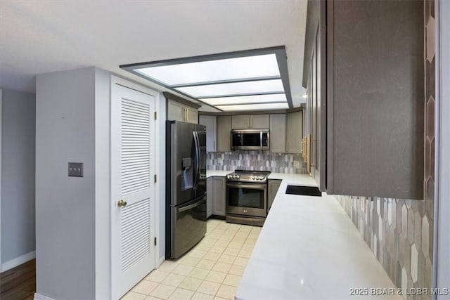 37 La Jolla Dr Unit 3C, Lake Ozark, MO 65049 - kitchen with stainless steel appliances, backsplash, light countertops, baseboards, and light tile patterned floors