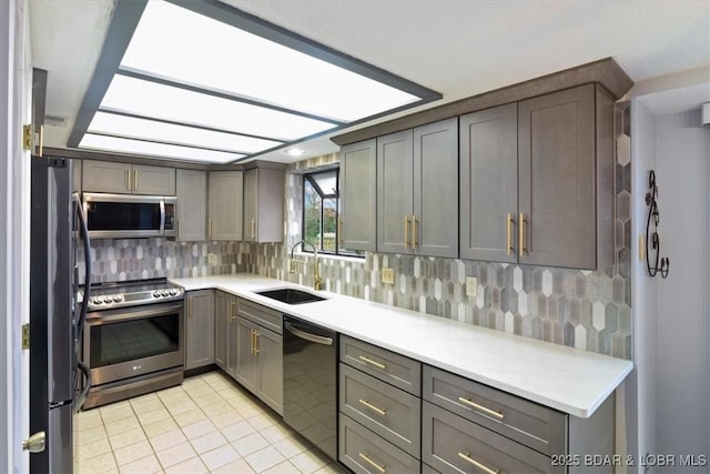 37 La Jolla Dr Unit 3C, Lake Ozark, MO 65049 - kitchen featuring stainless steel appliances, a sink, light tile patterned floors, light countertops, and tasteful backsplash