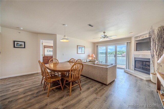 272 Cedar Glen Dr Unit 3A, Camdenton, MO 65020 - dining space featuring a high end fireplace, wood finished floors, ceiling fan, and baseboards