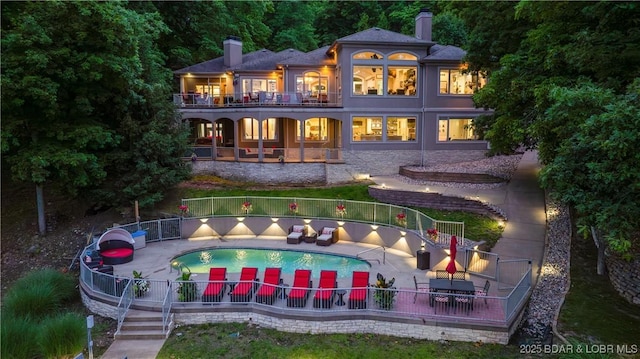 1453 Grand View Dr, Porto Cima, MO 65079 - back of property with a balcony, a chimney, and a patio