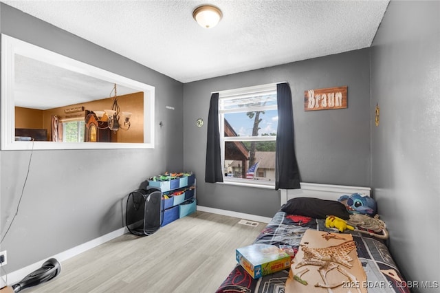 135 Tonka St, Camdenton, MO 65020 - game room with wood finished floors, healthy amount of natural light, a textured ceiling, and baseboards