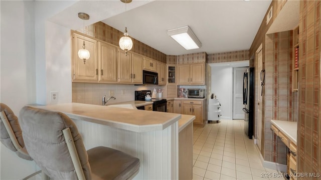 441 Northport Dr Unit 441, Lake Ozark, MO 65049 - kitchen featuring black appliances, light countertops, a breakfast bar, and a peninsula