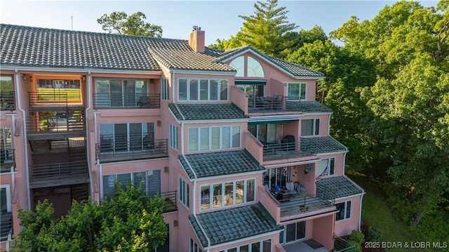 441 Northport Dr Unit 441, Lake Ozark, MO 65049 - back of property featuring a tiled roof, a chimney, and a balcony