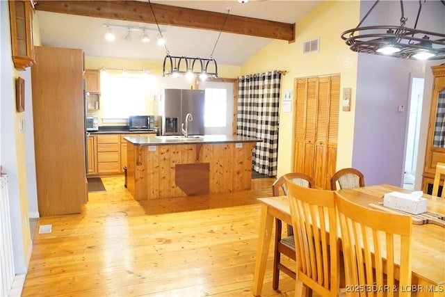 1025 Crystal Springs Rd, Linn Creek, MO 65052 - kitchen with stainless steel appliances, light wood finished floors, dark countertops, a sink, and an island with sink
