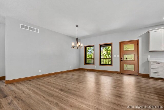 55 Turn Bridge Ln, Porto Cima, MO 65079 - unfurnished dining area featuring wood finished floors, a chandelier, and baseboards