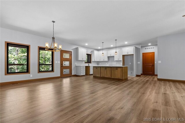 55 Turn Bridge Ln, Porto Cima, MO 65079 - kitchen with recessed lighting, light wood-style flooring, open floor plan, a chandelier, and white cabinets