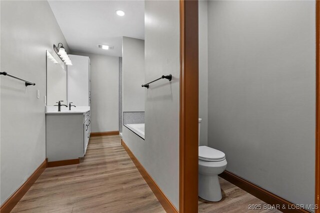 55 Turn Bridge Ln, Porto Cima, MO 65079 - full bathroom featuring toilet, vanity, a bath, and wood finished floors