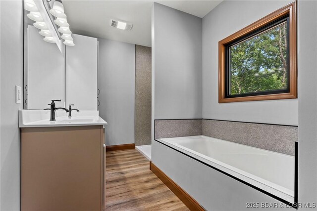 55 Turn Bridge Ln, Porto Cima, MO 65079 - full bath with vanity, a garden tub, wood finished floors, and baseboards