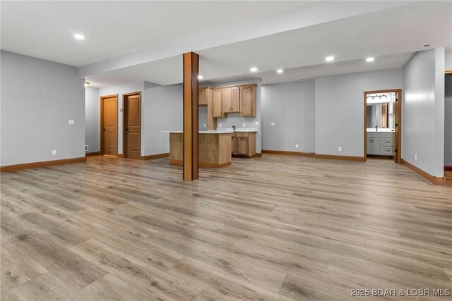 55 Turn Bridge Ln, Porto Cima, MO 65079 - unfurnished living room with baseboards, recessed lighting, light wood-style floors, and bar area