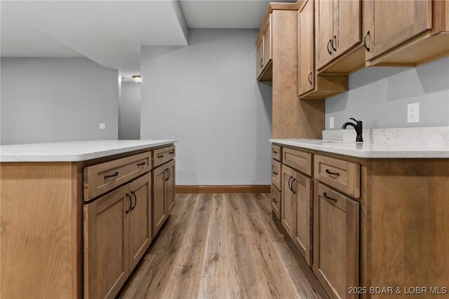 55 Turn Bridge Ln, Porto Cima, MO 65079 - kitchen with light wood-style flooring, a sink, baseboards, and a kitchen island