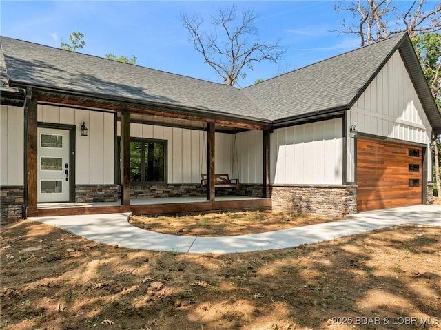 55 Turn Bridge Ln, Porto Cima, MO 65079 - view of front of house with roof with shingles, an attached garage, and stone siding